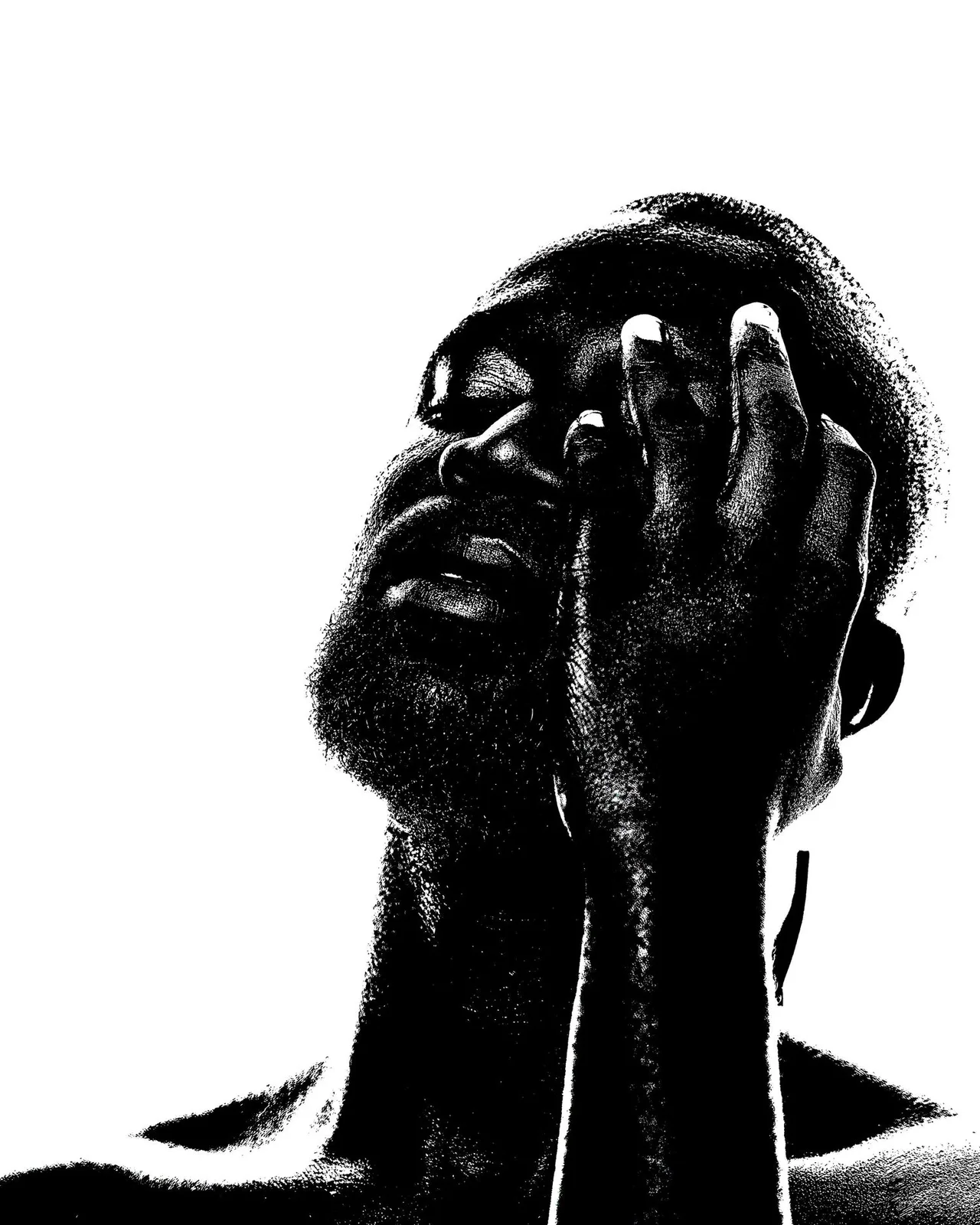 High contrast black and white photograph of a person with a beard in dramatic pose with hands covering face.