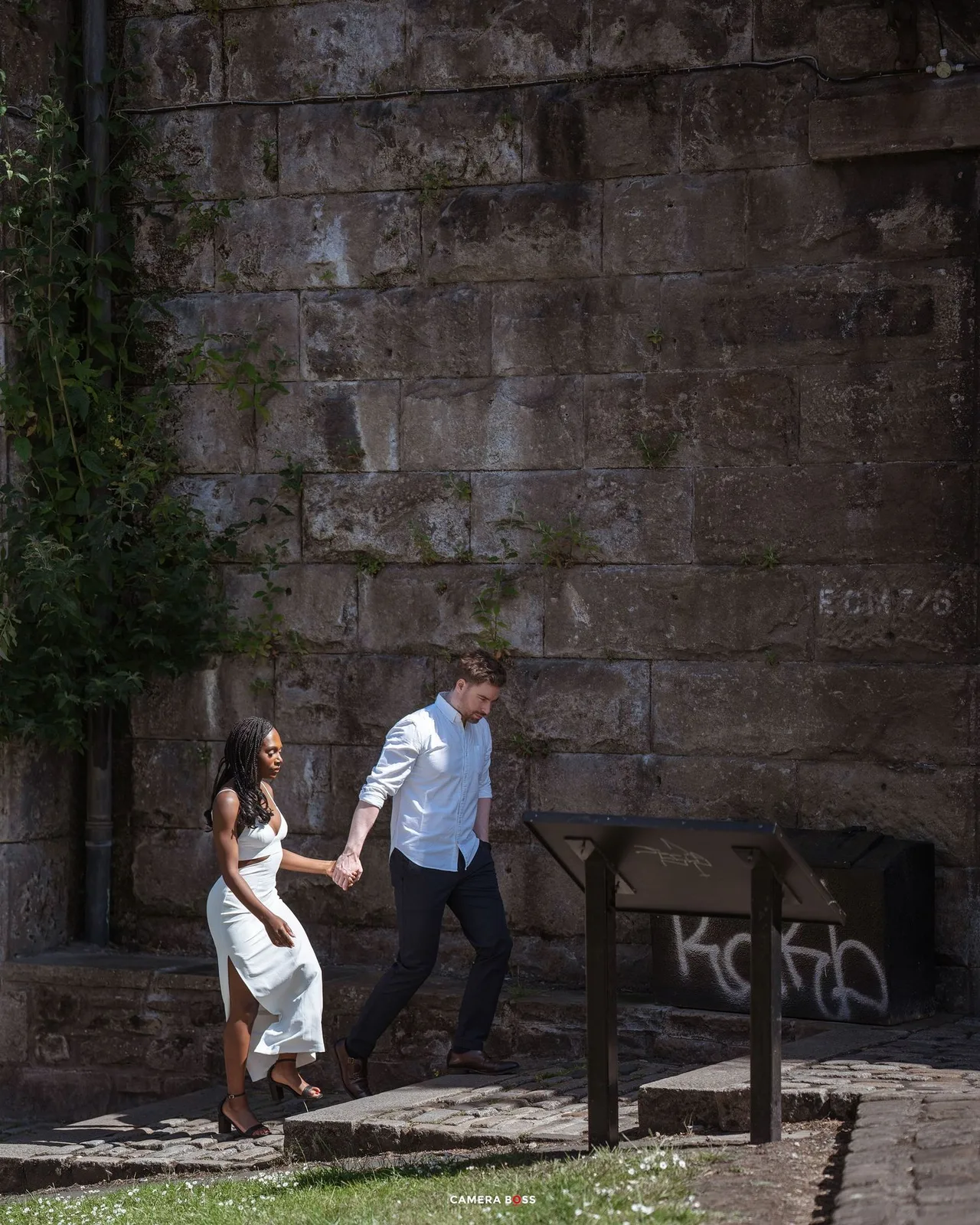 Series of dynamic parkour movements showing a person in white performing wall flips and acrobatics against a stone wall.