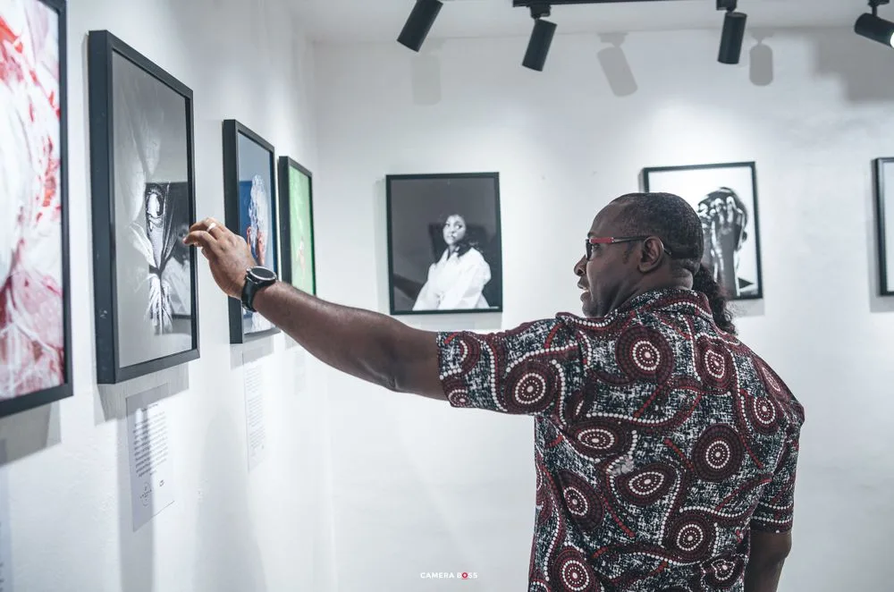 A visitor examining photographs at the Aworan exhibition