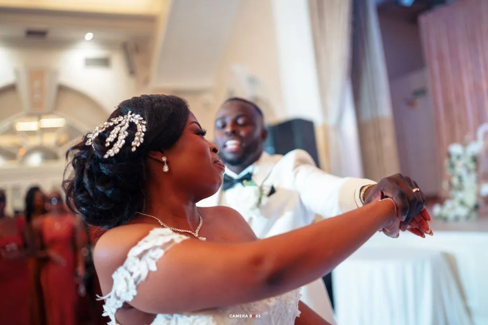 Dancing couple celebrates during their wedding reception in formal attire.