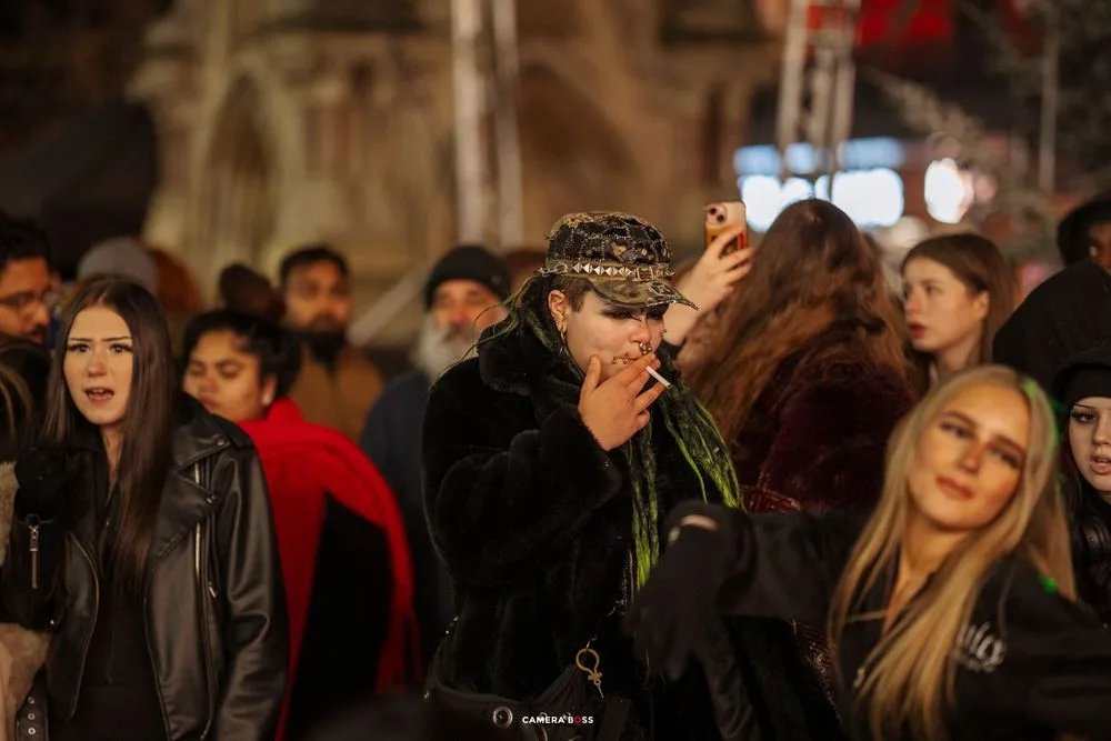 Crowd of people gathered at a dimly lit nighttime event or gathering.