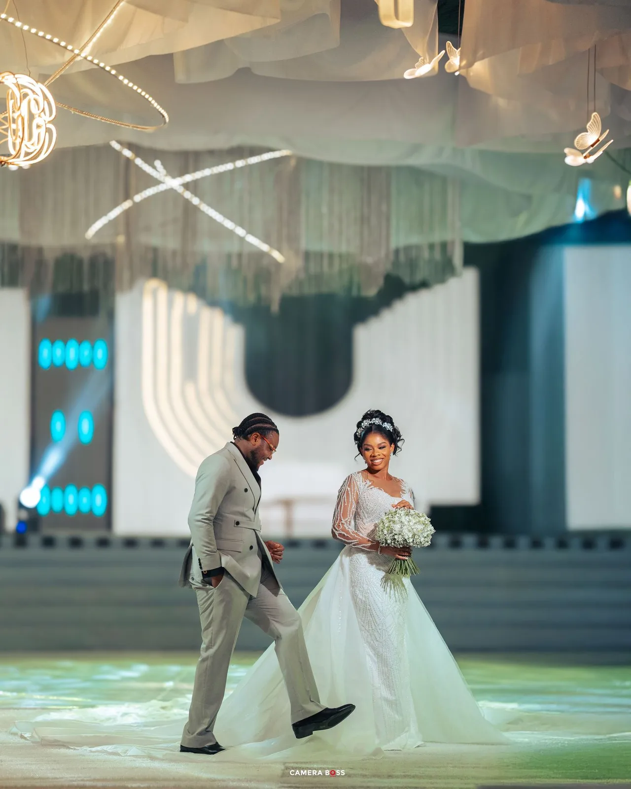 A couple celebrates their wedding day on a dramatically lit dance floor with white decor and ethereal lighting effects.