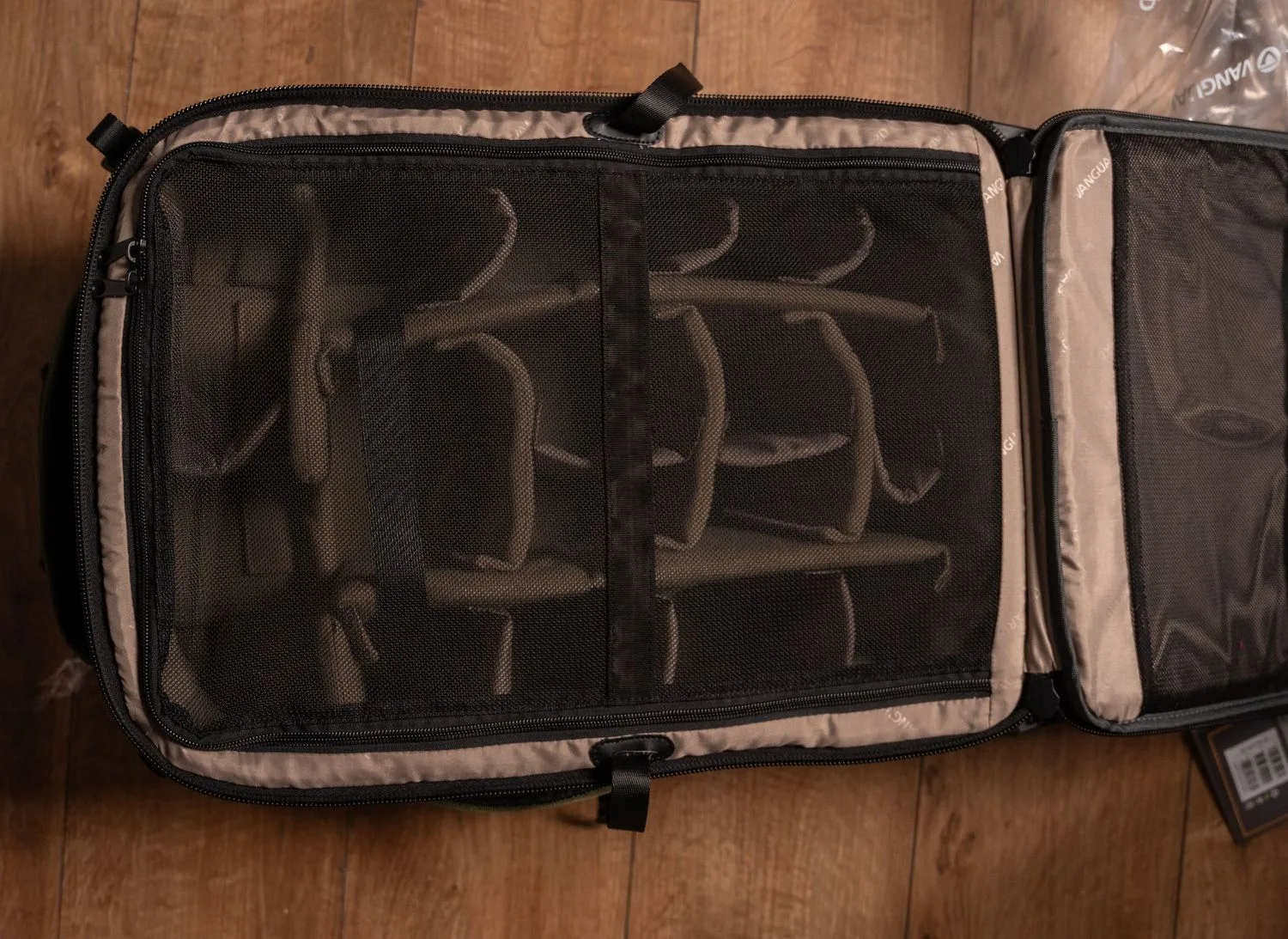 An organized packing cube or travel organizer with mesh compartments shows empty storage sections inside.