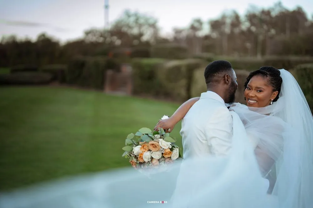 A wedding photoshoot featuring a bride in a flowing white gown with a bouquet in an outdoor garden setting.