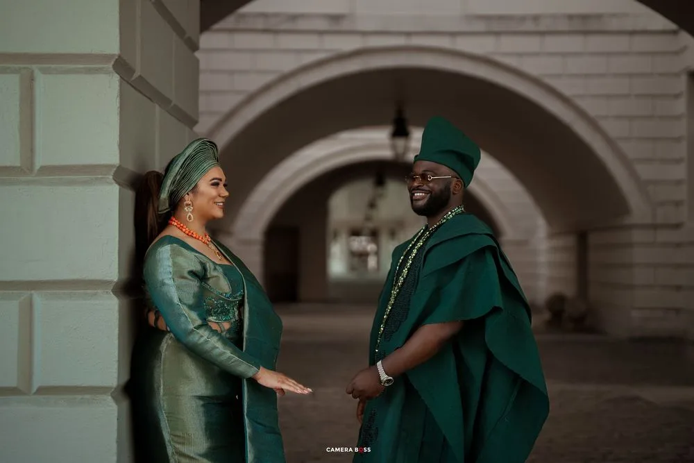 Dancers in coordinated green outfits performing an expressive routine in an architectural setting.