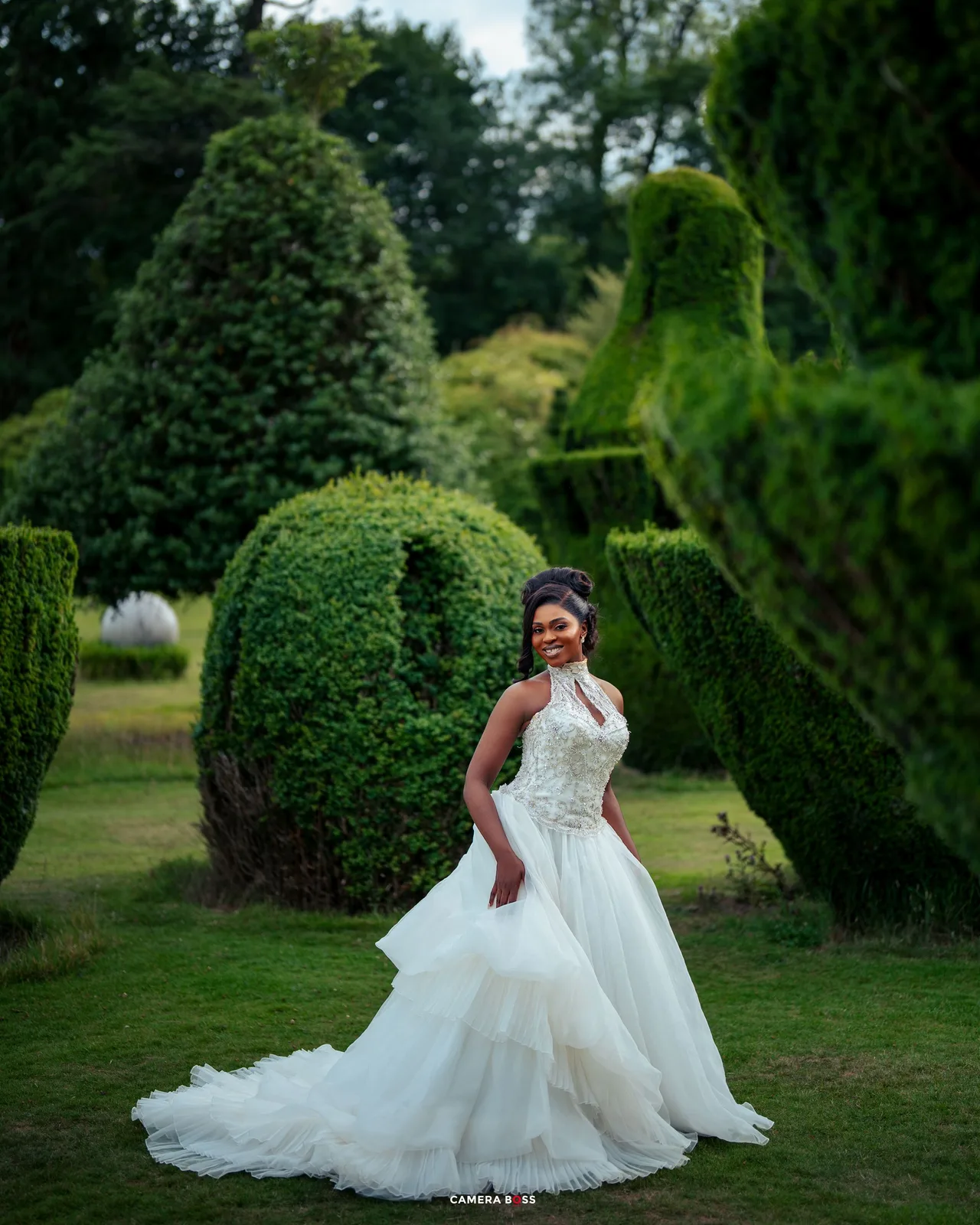 A series of consecutive photos showing a flowing white wedding dress against a backdrop of manicured garden hedges.