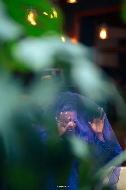 Artistic photo through leaves with blue tones and warm lights creating a dreamy, bokeh effect background.