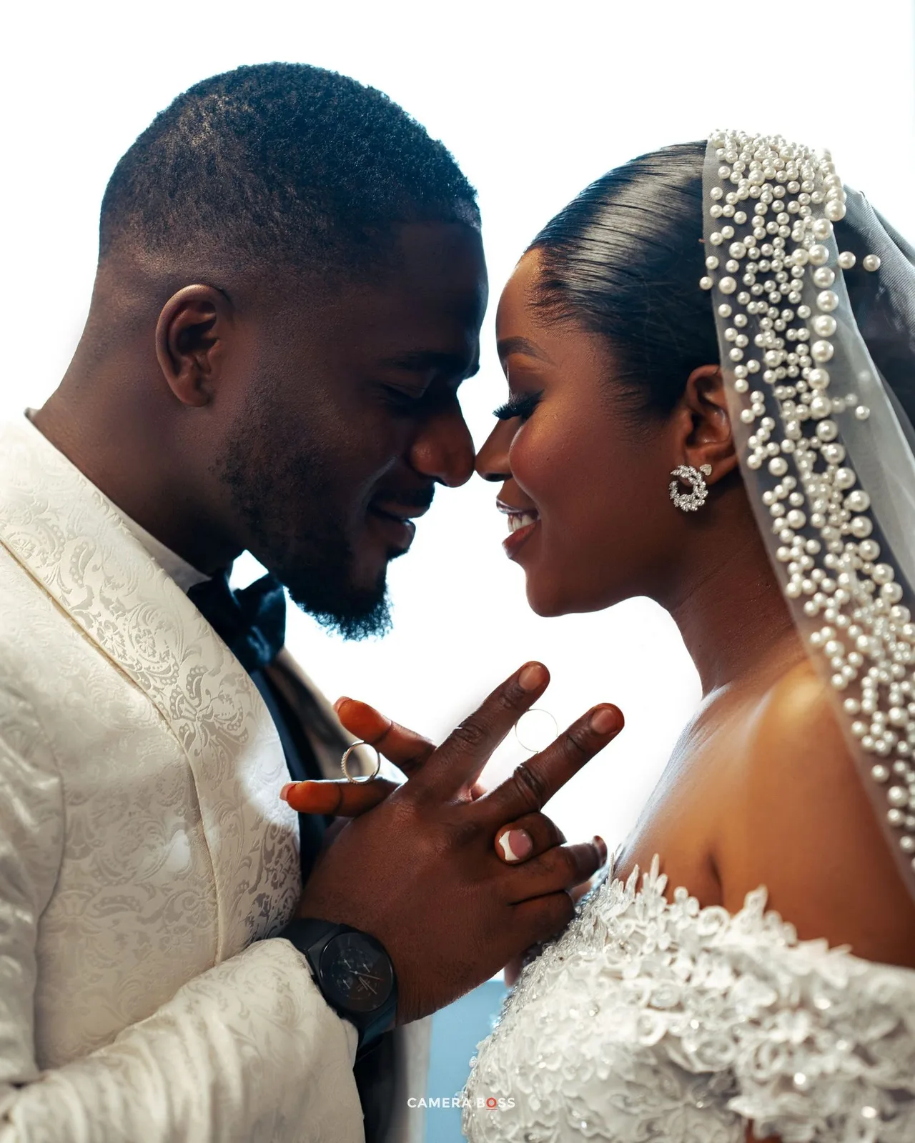 A romantic close-up of a newlywed couple in wedding attire sharing an intimate moment together.