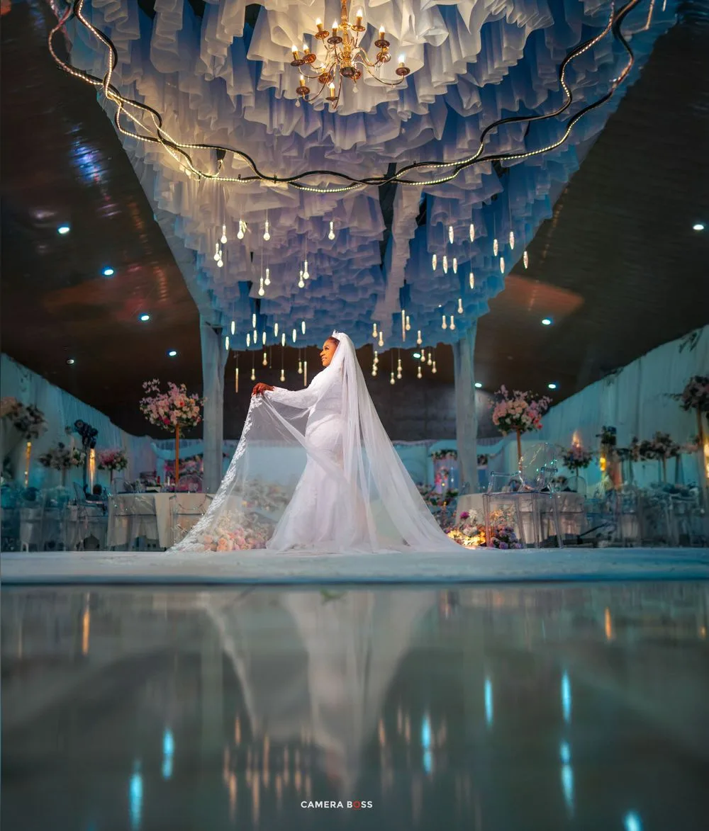 Ethereal wedding reception venue with floating candles, crystal chandeliers and reflective floor creating a magical atmosphere.