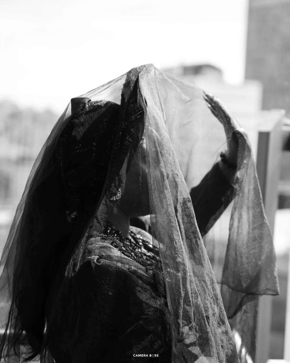 Vintage black and white photograph of a draped sheer fabric veil hanging delicately against a light background.