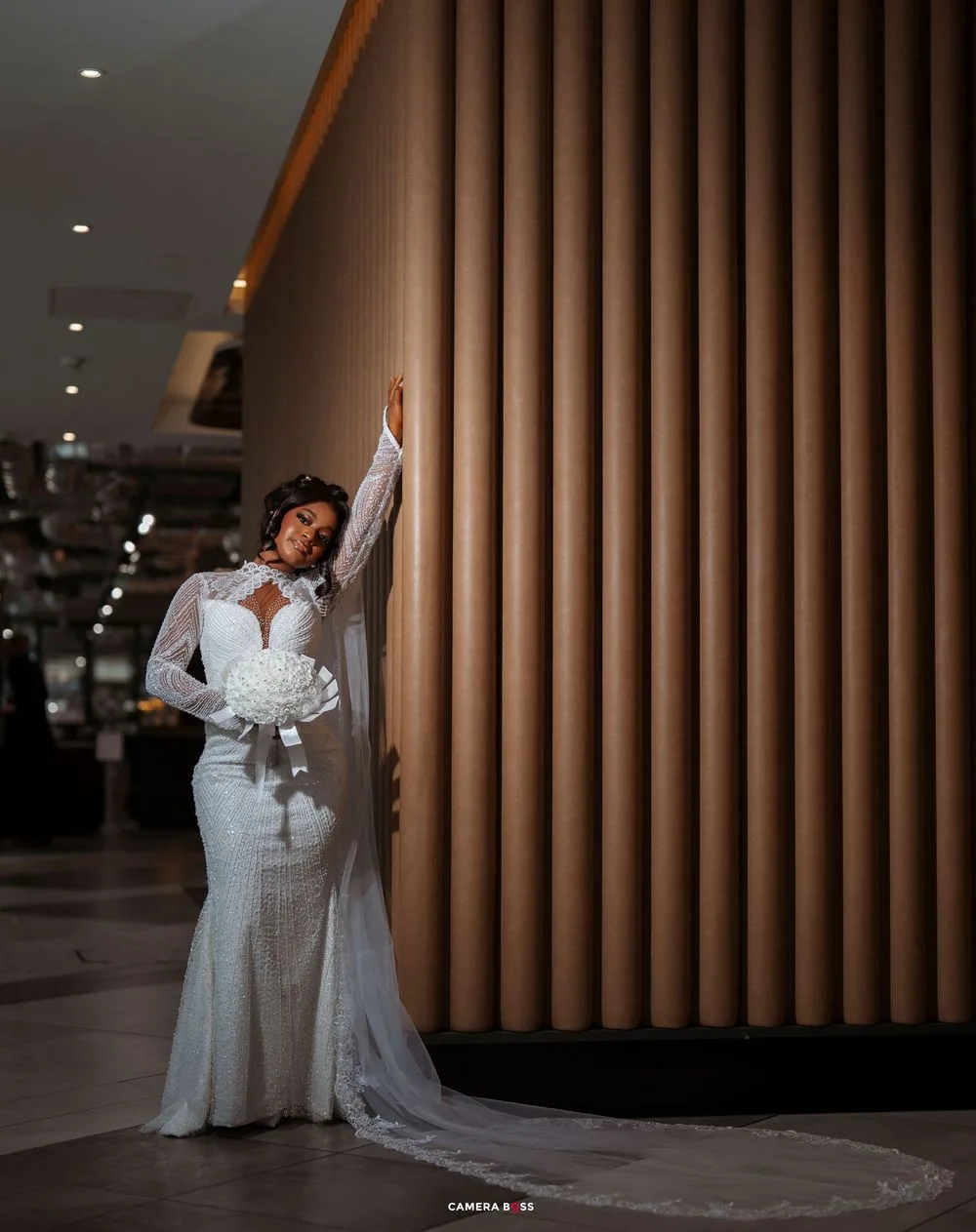 A romantic wedding photoshoot sequence against modern architectural columns with dramatic lighting and flowing white gowns.