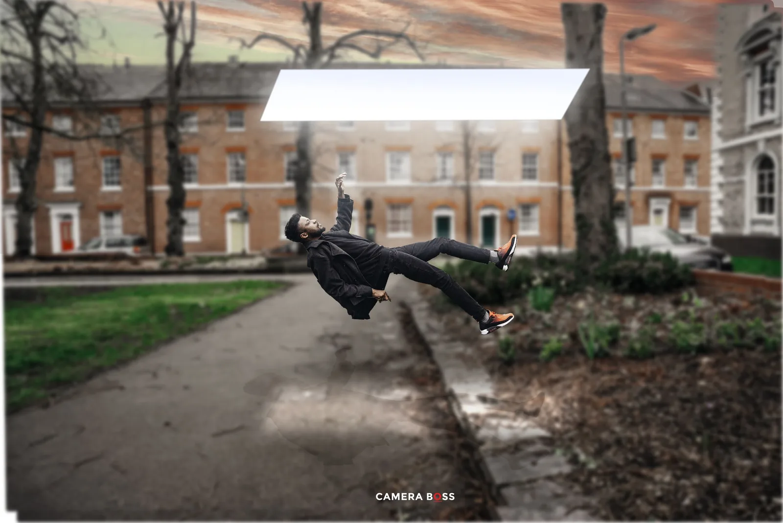Person performing an acrobatic side flip on a pathway in front of historic brick buildings at sunset.
