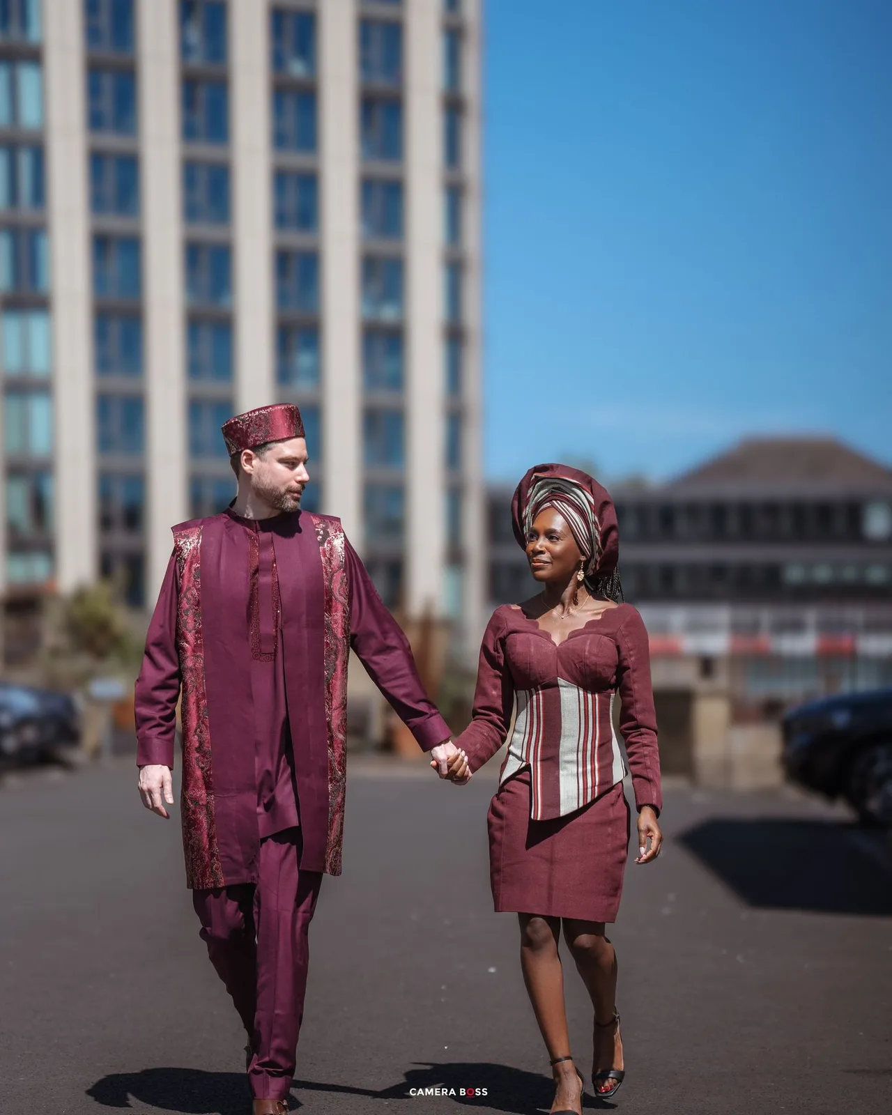Five consecutive photos showing a couple in matching burgundy outfits walking and holding hands on a paved surface.