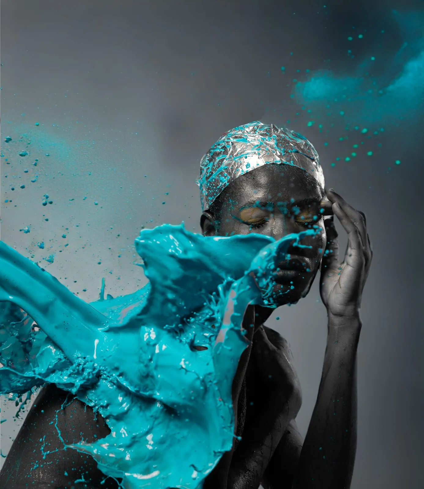 Artistic portrait with turquoise water splash effect against dark background creating dramatic visual impact.